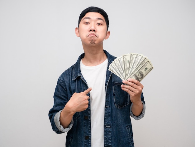 Young man jeabs shirt boast with money in hand point finger at himself isolated