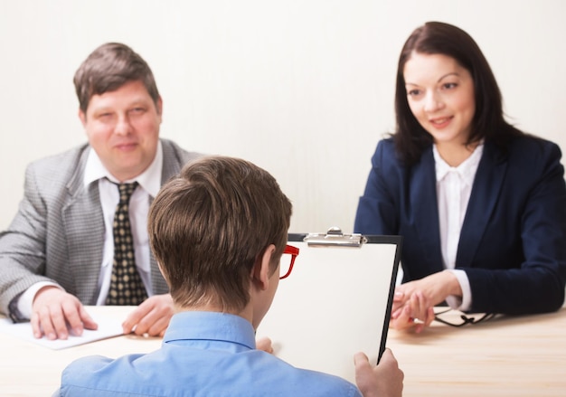 Young man during job interview and members of managemen