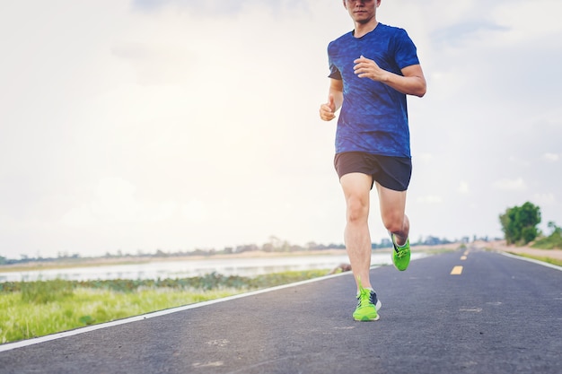 Young man jogging along the road.