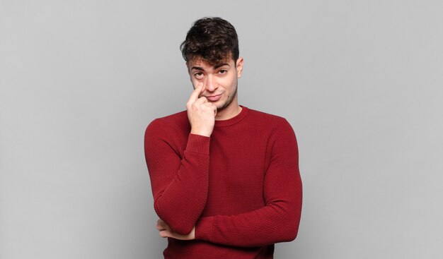 young man keeping an eye on you, not trusting, watching and staying alert and vigilant