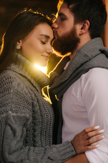 Young man kisses his girlfriend on the forehead