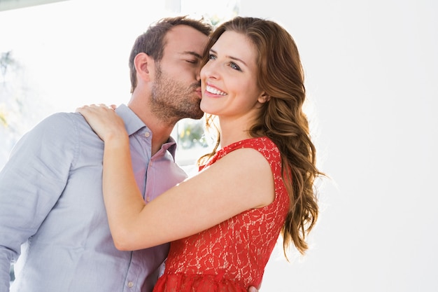 Young man kissing beautiful woman on cheek