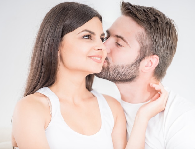 Young man kissing his woman tenderly at the cheek.