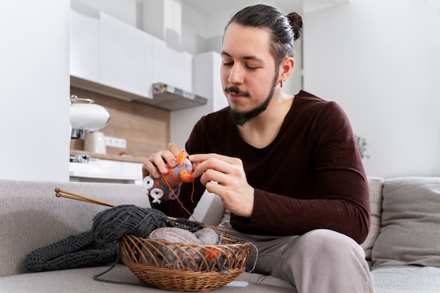 Photo young man knitting while relaxing