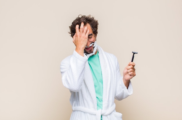 Photo young man laughing and slapping forehead