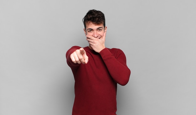 young man laughing at you, pointing  and making fun of or mocking you