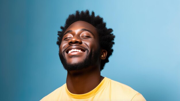 Young man laughs against a blue background