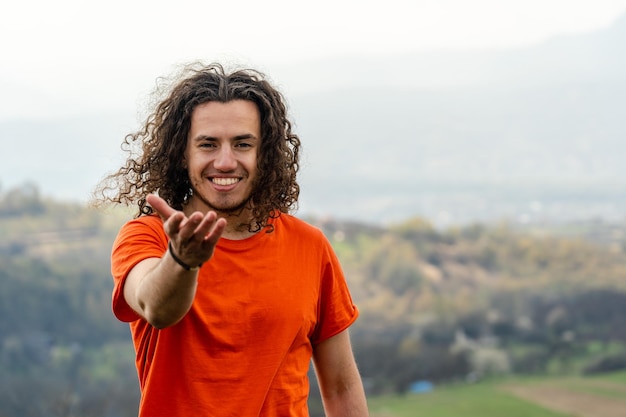 Young man laughs and fools on top of the mountain