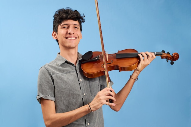 Young man learning violin isolated