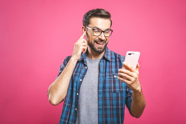 Young man listening music in headphones and dancing 