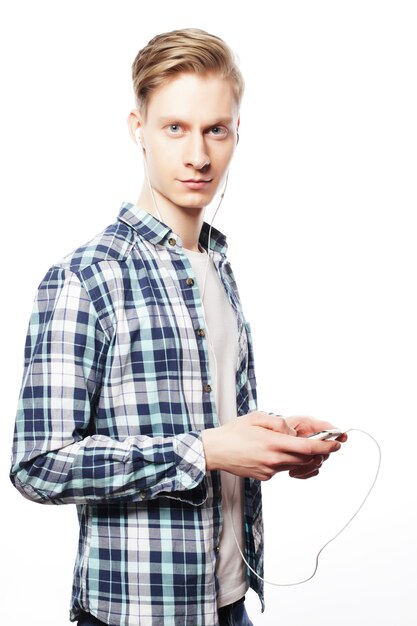 Young man listening to music isolated on white