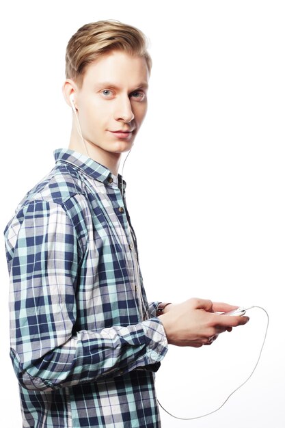 Young man listening to music isolated on white