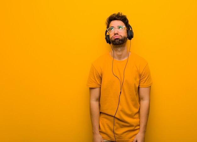 Young man listening to music tired and bored