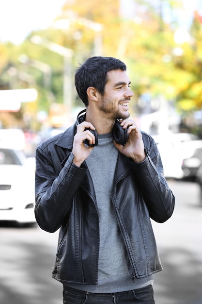 Young man listening to music and walking along the street