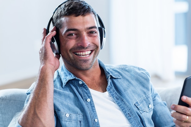 Young man listening to music while using mobile phone