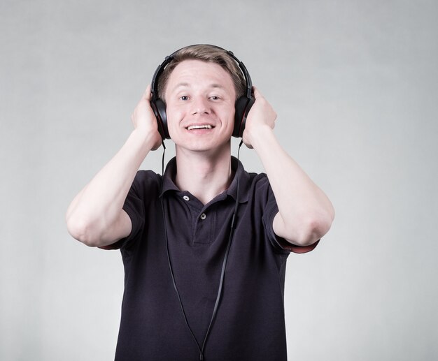 Young man listening music with headphones isolated