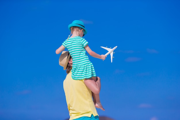 Young man and little girl with miniature of airplane at beach