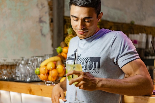 Young Man look into his fresh cocktail