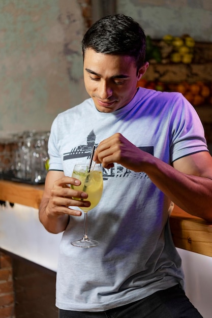 Young Man look into his fresh cocktail