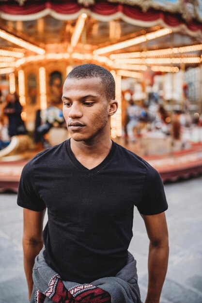 Photo young man looking away at amusement park