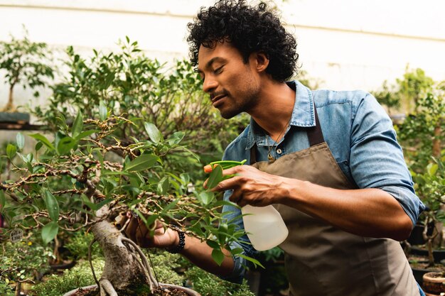 Photo young man looking away while holding plants