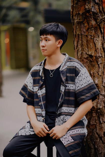 나무 줄기 근처 에 앉아 있는 젊은 남자