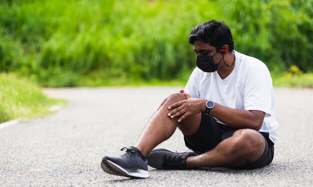 Young man looking away while sitting outdoors