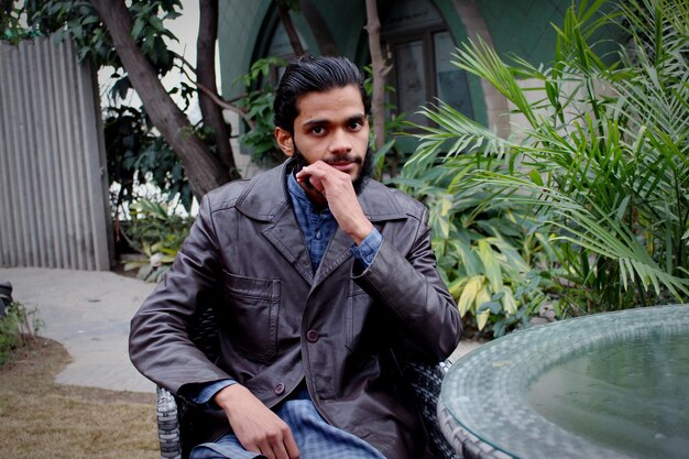 Young man looking away while sitting at park