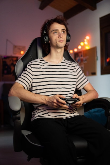 Photo young man looking away while sitting on sofa