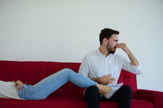 Young man looking away while sitting on sofa