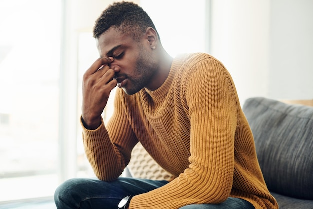 Young man looking away while sitting on sofa