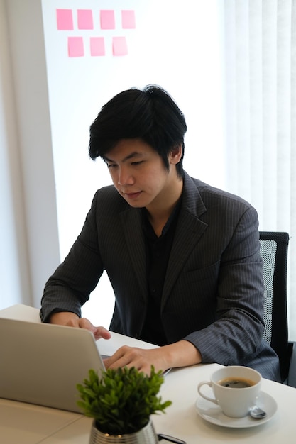 テーブルに座っている若い男が目をそらしている