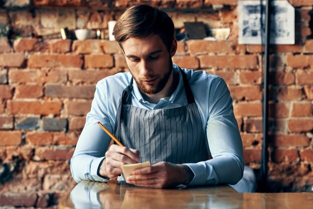 Photo young man looking away while sitting on table