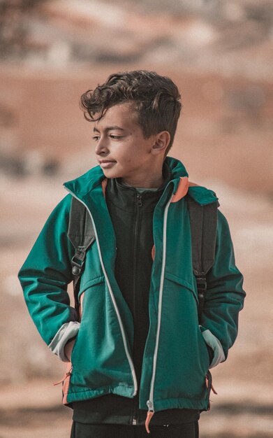 Photo young man looking away while standing outdoors