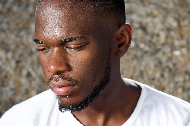 Young man looking away with sweat dripping down face