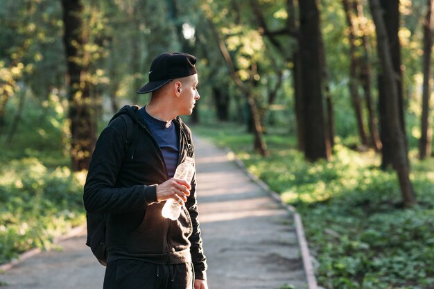 Young man looking back on forest road