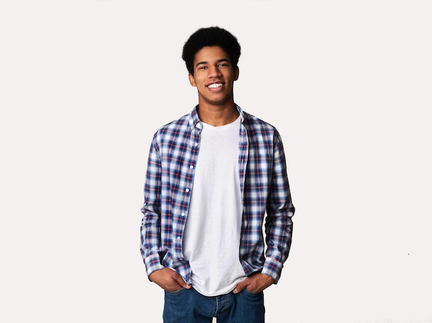 Young man looking at camera and holding hands in pockets