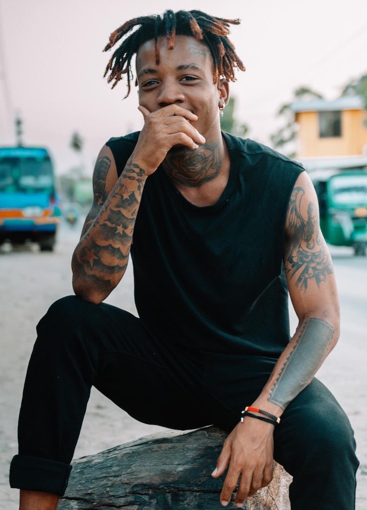 Photo young man looking at camera while sitting outdoors