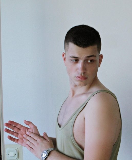 Young man looking down by wall at home