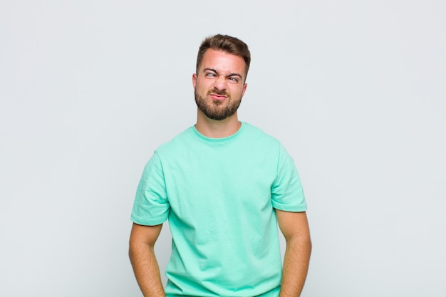 Young man looking goofy and funny with a silly cross-eyed expression, joking and fooling around