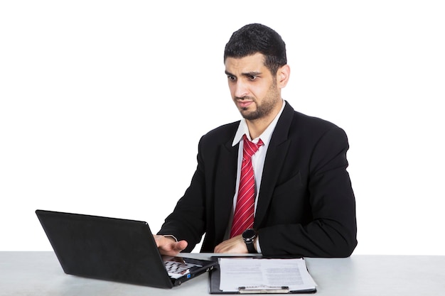 Young man looking at laptop with confused expression