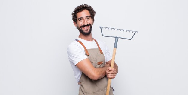 Young man looking like a happy, proud and satisfied achiever smiling with arms crossed