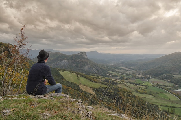 Young man looking  the mountain at sunset