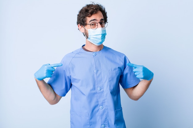 Young man looking proud, positive and casual pointing to chest with both hands. coronavirus concept