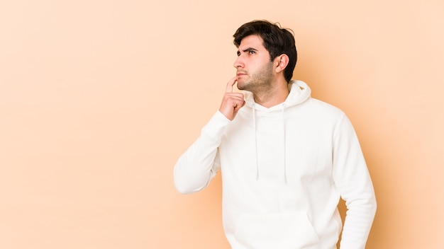 Young man looking sideways with doubtful and skeptical expression.