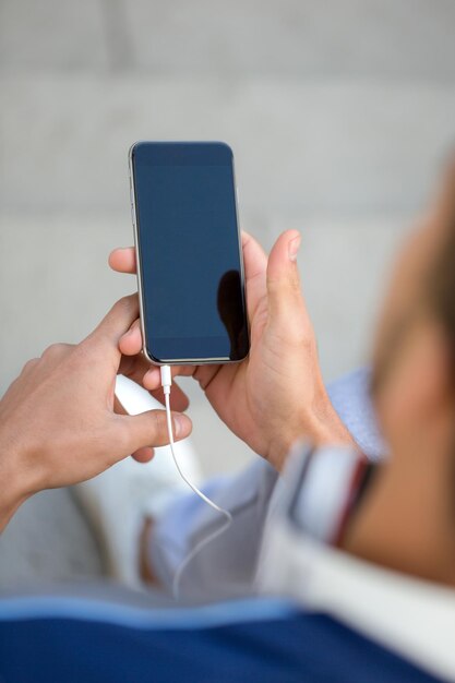 Young man looking at smartphone smart cell phone using\
cellphone copyspace copy space portrait format