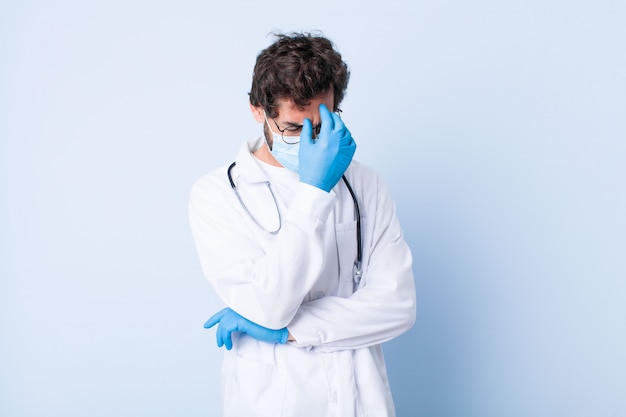 Young man looking stressed, ashamed or upset, with a headache, covering face with hand. coronavirus concept