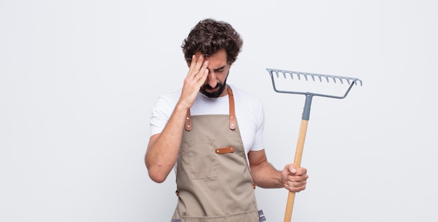 Young man looking stressed and frustrated, working under pressure with a headache and troubled with problems