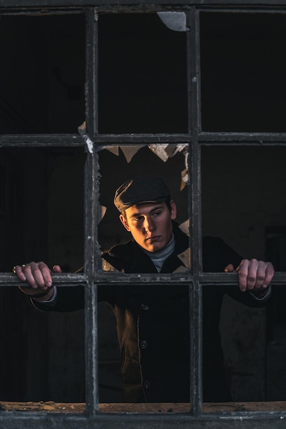 Young man looking through prison bar