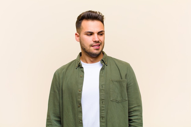 Young man looking worried, stressed, anxious and scared, panicking and clenching teeth over isolated wall